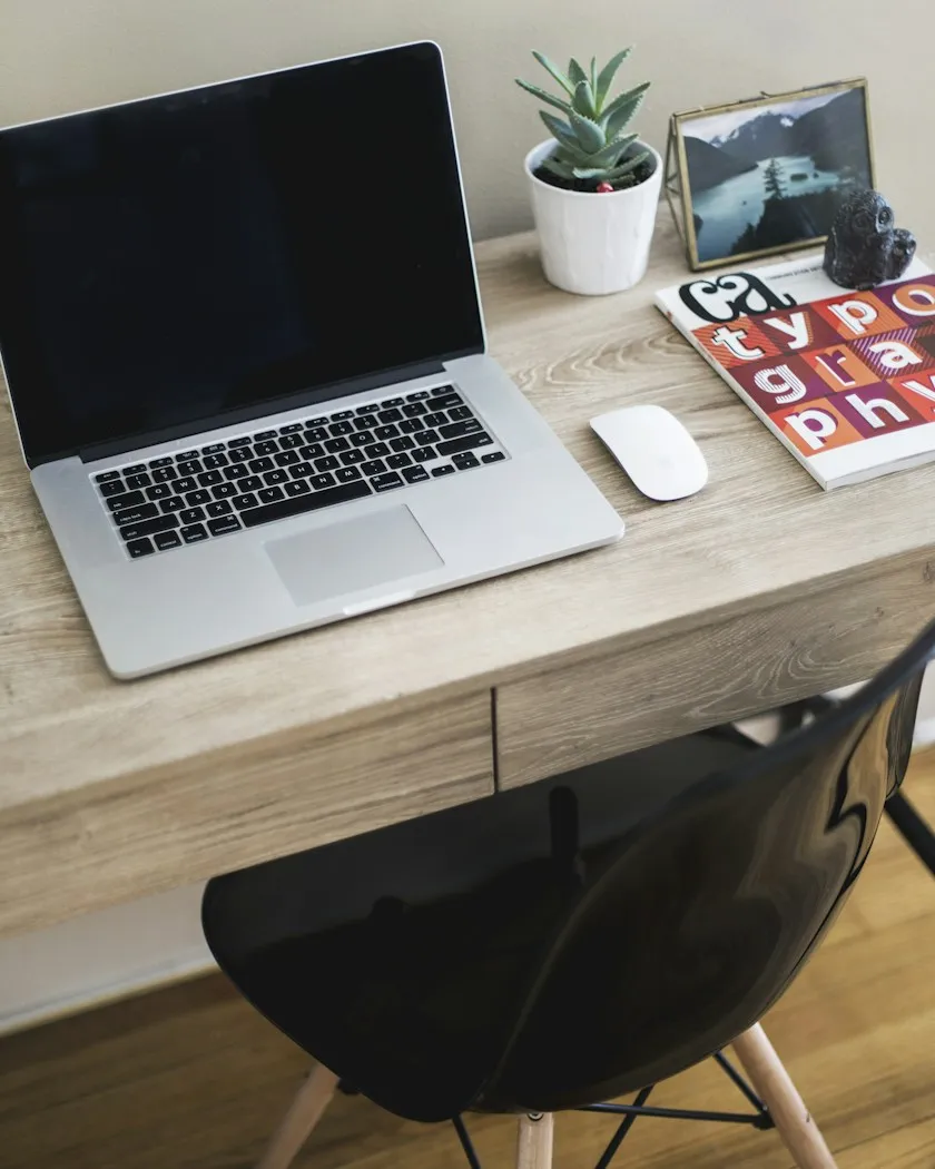 Arbeitsplatz von Studio Georg — Laptop, Notizbuch und Typografie-Buch (Symbolbild)