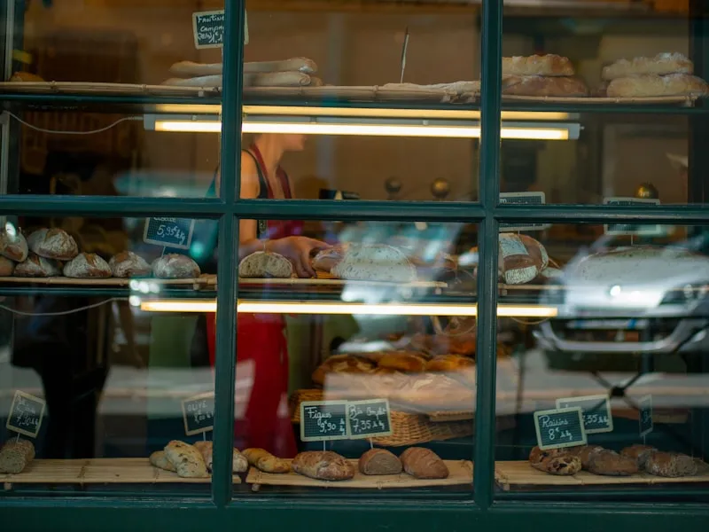 Schaufenster einer Bäckerei mit Broten und Preisschildern